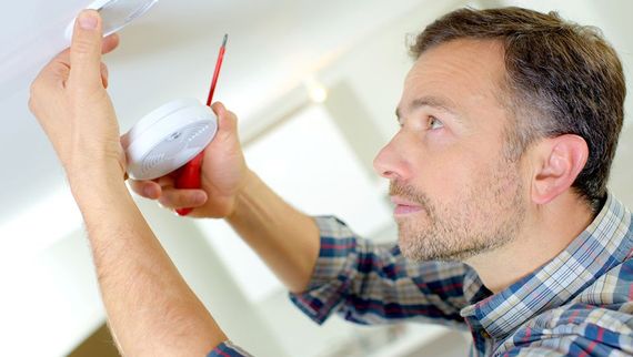 Guy fitting fire alarm